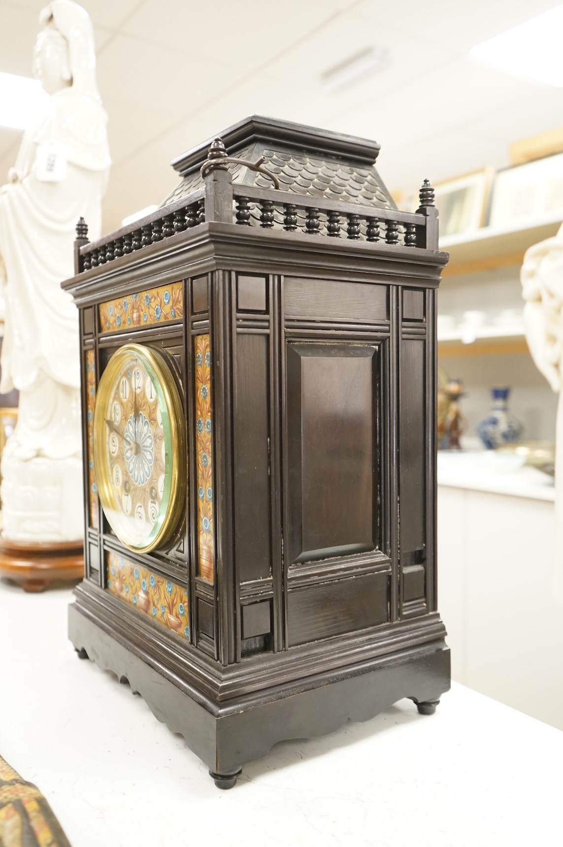 A Victorian Aesthetic Movement ebonised architectural mantel clock, probably designed by Lewis Foreman Day, the eight day chiming movement marked G.V. no. 39837, with Elourdelet lever, with figure and foliage decorated g